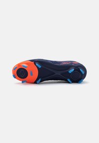 Botas de fútbol con un upper azul marino, talón naranja y tachuelas azules. Presenta una suela texturizada con un diseño de agarre patternado para tracción.