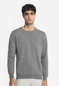 Szary sweter wykonany z dzianiny, z okrągłym dekoltem, długimi rękawami, żebrowanymi mankietami i dopasowanym pasem. Minimalistyczny design.