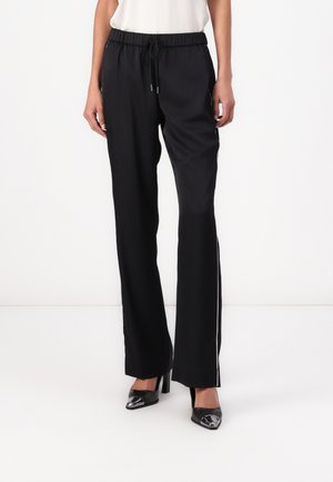 Black athletic pants with an elastic waistband and drawstring. Features side stripes and a straight leg design. Pairing with black high heels.