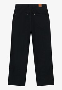 Mustat leveät housut, jotka on valmistettu tekstuurisesta kankaasta. Housuissa on kaksi takataskua ja nahkaleima vyötäröllä.