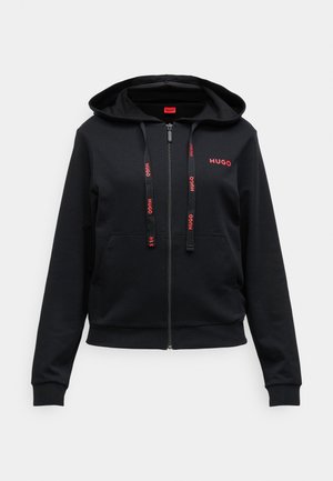 Svart zip-up hoodie i mjukt tyg, med huva, framfickor och röd "HUGO" logga på bröstet och dragsko.