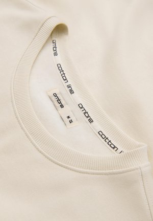 Katoenen crewneck sweatshirt in lichtbeige, met een geribbelde halslijn en een binnenlabel met de merknaam "ombre" en maatinformatie.