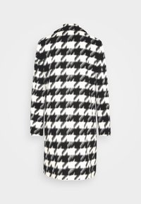 Uldblandet frakke med et sort og hvidt houndstooth mønster, lange ærmer, klapkrave og en åben rygdesign.