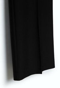 Black trousers made of smooth, lightweight fabric, featuring a straight cut and clean lines with a subtle matte texture.