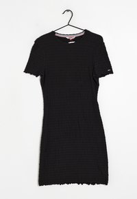 Svart klänning med korta ärmar och en texturerad, krinklad design. Den har en rund halsringning med röda och vita randiga detaljer.