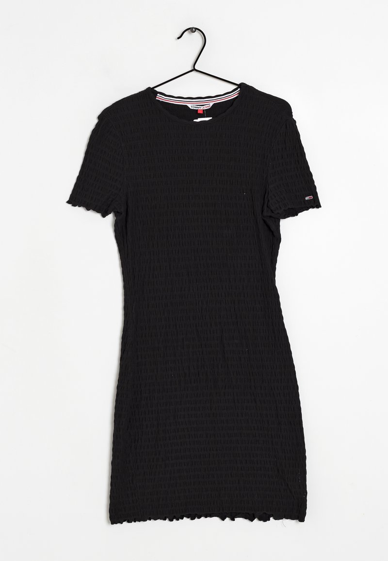 Svart klänning med korta ärmar och en texturerad, krinklad design. Den har en rund halsringning med röda och vita randiga detaljer.