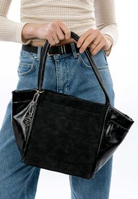 Must_have musta käekott, millel on tekstuuriga matt viimistlus ja läikivad detailid. Omab kaht käepidet ja ketidetaili. Sobitatud kõrge vöökohaga teksadega.