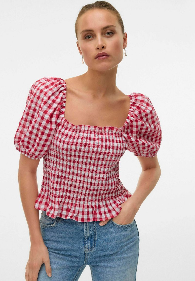 Top a maniche puff in quadrato rosso e bianco a scacchi, con scollatura quadrata, tessuto arricciato e orlo arruffato, abbinato a jeans in denim blu.