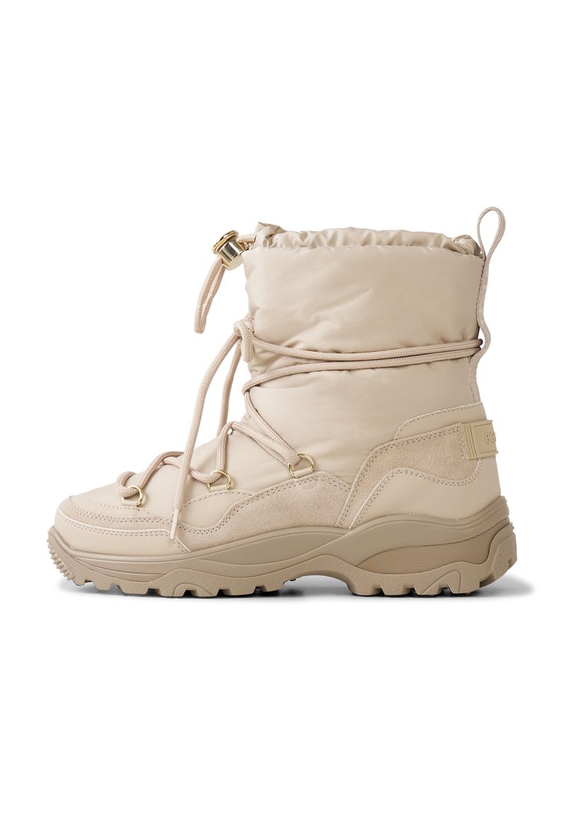 Beżowy wodoodporny but z miękką, wyściełaną cholewką, systemem sznurowania, gumową podeszwą i złotymi akcentami metalowymi. Charakteryzuje się teksturowaną cholewką i solidnym kształtem.