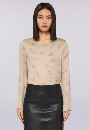 Beige blouse met lange mouwen, voorzien van een grijze lijntekening van rennende honden over het gehele oppervlak; gladde textuur, ronde halslijn en een getailleerd ontwerp.