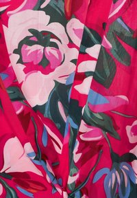 Kwiatowa sukienka o kroju wrap z żywym różowym tłem, dużymi białymi i zielonymi kwiatami, akcentowana niebieskimi liśćmi i miękką fakturą.