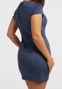 Kurzes navyblaues Kleid mit figurbetontem Schnitt, kurzen Ärmeln, strukturiertem Finish und einer sichtbaren Nahtdetails hinten.