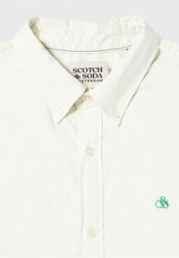 Lichtgekleurde button-up shirt van katoen, met een omklapbare kraag, een klein groen geborduurd logo en een standaard knoopsluiting.