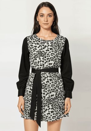 Vestido de estampado de leopardo con falda corta, mangas largas negras y un cinturón a juego. Tejido suave al tacto, escote redondo y puños elásticos.
