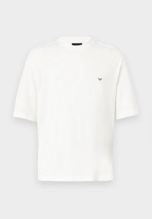 Άσπρο κοντομάνικο t-shirt με στρογγυλή λαιμόκοψη και μικρό μαύρο λογότυπο στο αριστερό στήθος, απεικονισμένο σε απλό ανοιχτό γκρι φόντο.