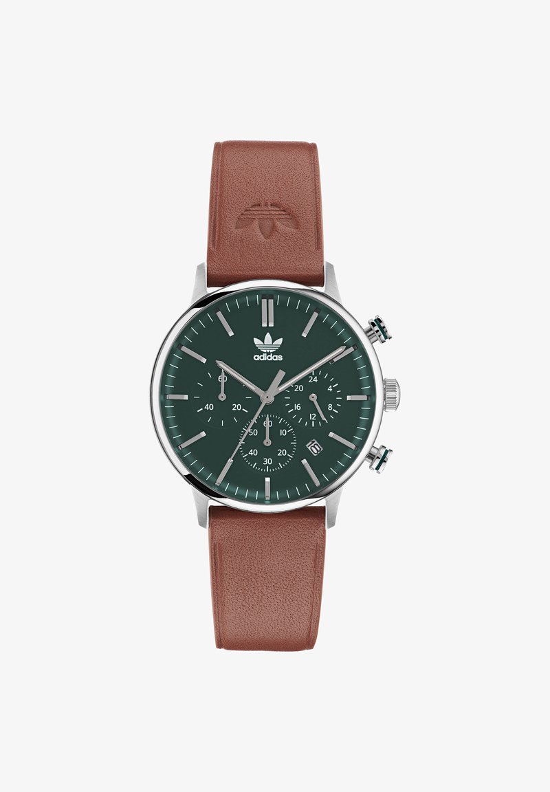 Roheline lõuendi kell koos hõbedaste detailidega, pruun nahkrihm, kronograafi funktsioonid ja kuupäeva näidik umbes kella 4 juures.