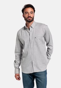 Grijze langarmige overhemd met knopen en een zak, met een zachte textuur en subtiel visgraatpatroon, gecombineerd met blauwe jeans.