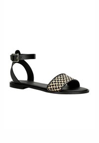 Black leather sandal with a wide woven strap featuring a houndstooth pattern in cream. Ankle strap with adjustable buckle. Flat sole.