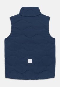 Gilet rembourré bleu marine avec un col haut, texture matelassée présentant des motifs en vagues, et une petite étiquette logo blanche au bas.