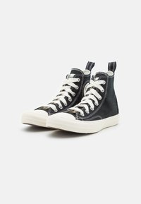 Zwarte hoge canvas sneakers met witte veters, rubberen neuskap en crèmekleurige zool, voorzien van contrasterende stiksels en hiel lus.