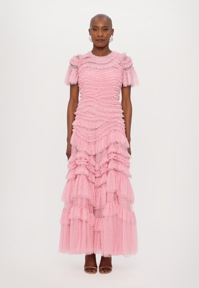Roze maxi-jurk met gelaagd, gerimpeld tule-ontwerp. Korte mouwen, textuur in het lijfje en stippenaccenten. Open teen schoenen complementeren de look.