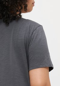 Grå kortermet t-skjorte med avslappet passform, laget av myk, strukturert tekstil. Har et subtilt heather-mønster og en uprydet design.
