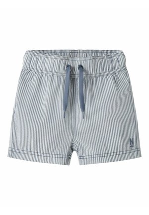 Lette blå og hvite vertikale stripete shorts med elastisk midjebånd og blå snorer, liten logo nær ermekanten på ensfarget bakgrunn.