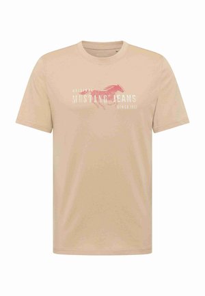 Beige Kurzarm-T-Shirt mit Rundhalsausschnitt, mit einem roten Mustang-Grafik und weißem Text "Original Mustang Jeans Seit 1932" auf der Brust.