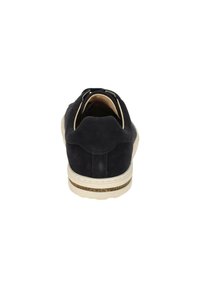 Zapato de ante azul marino con puntera redondeada y suela blanca, que presenta un reverso texturizado y un pequeño lazo para facilitar su uso.