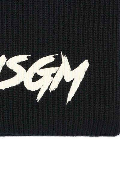 Beanie nero lavorato a maglia con un logo grafico bianco testurizzato in evidenza. Il design include lettere audaci e frastagliate su uno sfondo a coste.