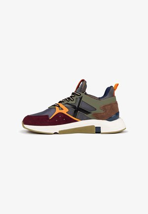 Zapatilla deportiva que presenta una combinación de gris, verde oliva, burdeos y acentos en naranja. Fabricada con malla, ante y goma, con una suela texturizada.