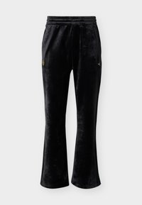 Schwarze Velours-Trainingshose mit ausgestellten Beinen, elastischem Bund und kleinen goldenen Logos auf jedem Oberschenkel vor einem schlichten weißen Hintergrund.