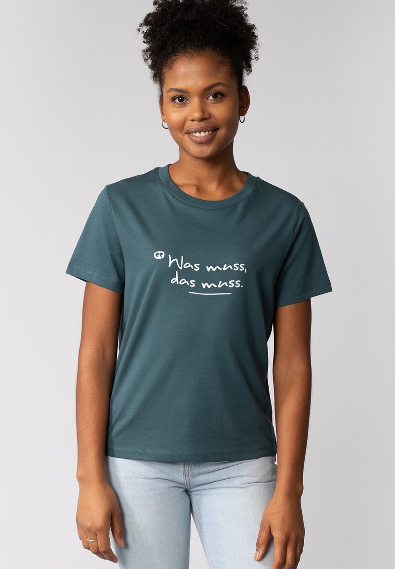 Turquoise katoenen T-shirt met een ronde hals en korte mouwen, voorzien van witte tekst: "Was muss, dat muss." Casual pasvorm.