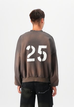 Oversized gray sweatshirt with faded, textured number "25" prominently displayed on the back. The design features a ribbed collar and cuffs.