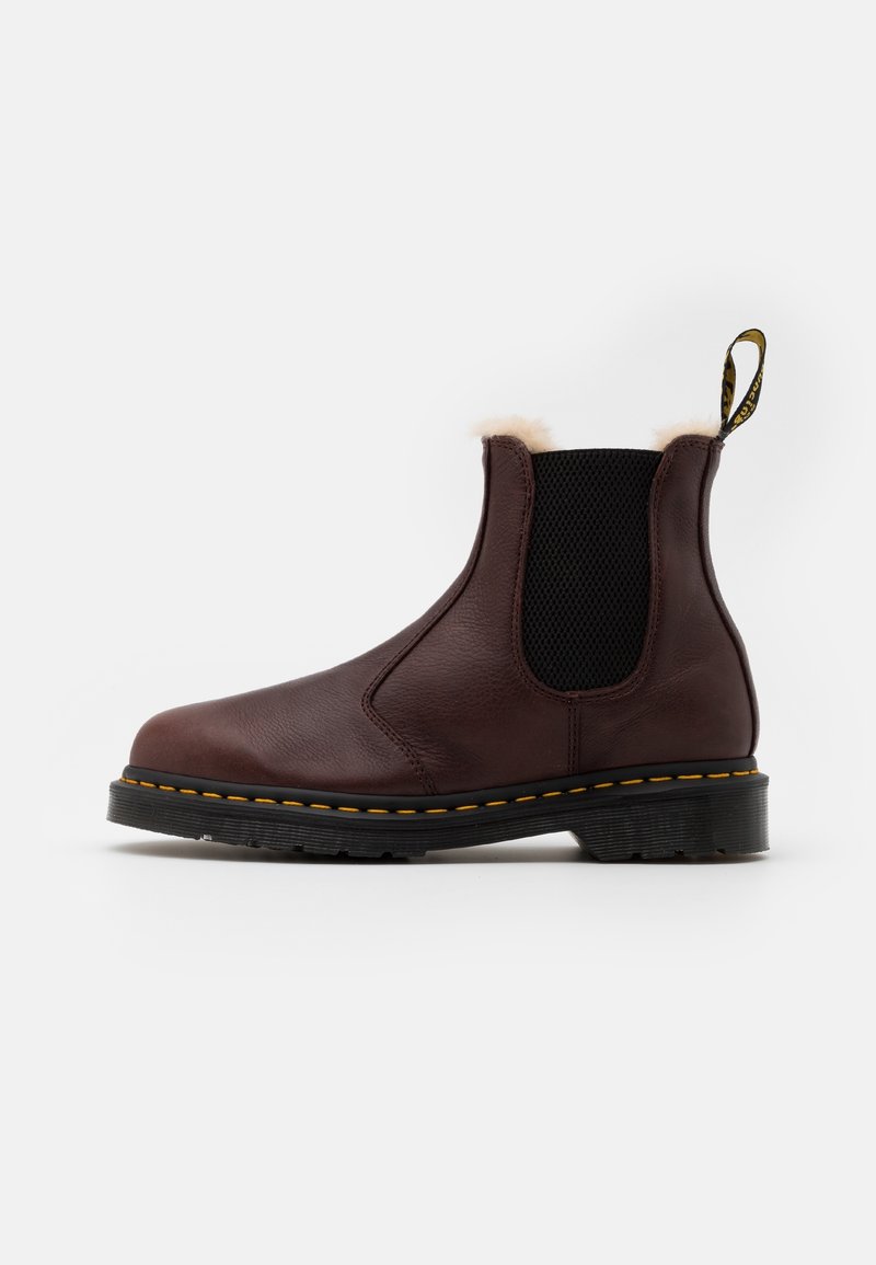Botte Chelsea en cuir marron avec une finition texturée, panneaux latéraux élastiques, col en fourrure et coutures jaunes sur une semelle noire.