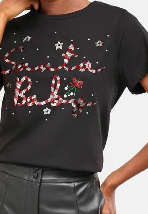 Zwart shirt met korte mouwen en rode en witte pailletten met de tekst "Santa Baby", versierd met kleine witte parels, sterren en groene en rode maretakken.