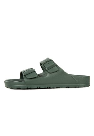 Sandale en caoutchouc vert avec deux sangles réglables, semelle texturée et semelle crantée pour une meilleure adhérence. Design minimaliste avec côtés ouverts.