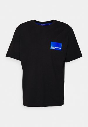 Crna pamučna majica s okruglim izrezom i kratkim rukavima, s plavim dizajnom kvadratne džepne oznake na kojoj je bijeli tekst "Karl Lagerfeld Jeans".