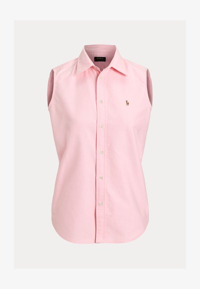 Chemise sans manches rose clair en coton, boutonnée sur le devant, avec un col pointu et un petit logo brodé sur le côté gauche de la poitrine.