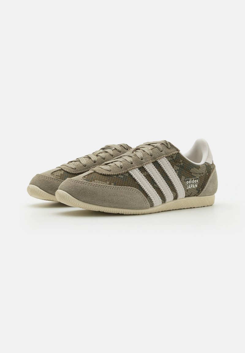 Groene en grijze suède sneakers met witte strepen, gestructureerde stof, vetersluiting en rubberen zool. 'Adidas Japan' logo aan de zijkant.