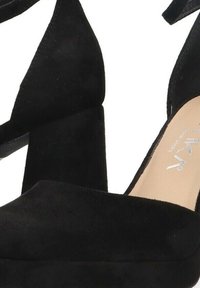 Zapatos de tacón alto de ante negro con plataforma, punta abierta y diseño de tiras entrelazadas. Textura suave, tacón robusto y cuadrado.