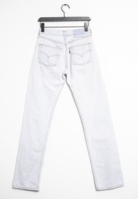 Jeans rectos de color azul claro con dos bolsillos traseros, costuras contrastantes y una etiqueta en la cintura. El material es denim con una textura suave.