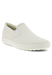 White slip-on shoes with a textured leather upper, elastic accents on the sides, and a lightweight rubber sole. Rounded toe design.