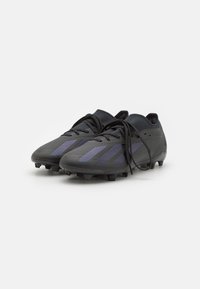 Zwarte voetbalschoenen met een strak ontwerp, een textuur bovenkant, drie paarse strepen en zwarte veters, met een geprofileerde zool voor grip.