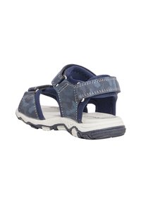 Sandalo blu navy con motivo camouflage, cinturini regolabili, suola testurizzata e interno imbottito. Presenta dettagli bianchi sulla suola.
