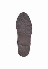 Semelle de chaussure synthétique marron avec un motif texturé et un logo, conçue pour l'adhérence et la durabilité.