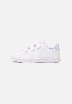 Sneaker bianco con tre cinturini in velcro, materiale sintetico liscia, dettagli perforati e un accento iridescente sul tallone.