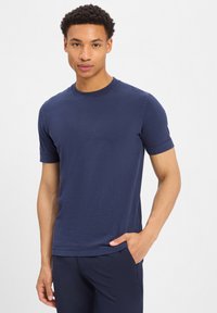 Granatowa koszulka z krótkim rękawem, wykonana z miękkiego, lekkiego materiału, z okrągłym dekoltem i luźnym krojem. Gładka tekstura i prosty design.