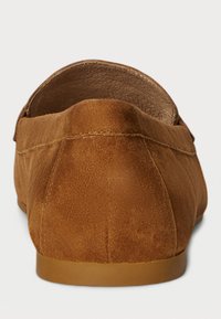 Hnědé semišové loafers s kulatou zadní částí, plochou gumovou podrážkou a viditelným šitím podél švů, které ukazují jemnou texturu.
