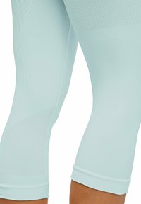 Hellblaue Sportleggings mit strukturiertem Muster, figurbetontem Schnitt und geripptem Bund. Das Material ist dehnbar und atmungsaktiv.